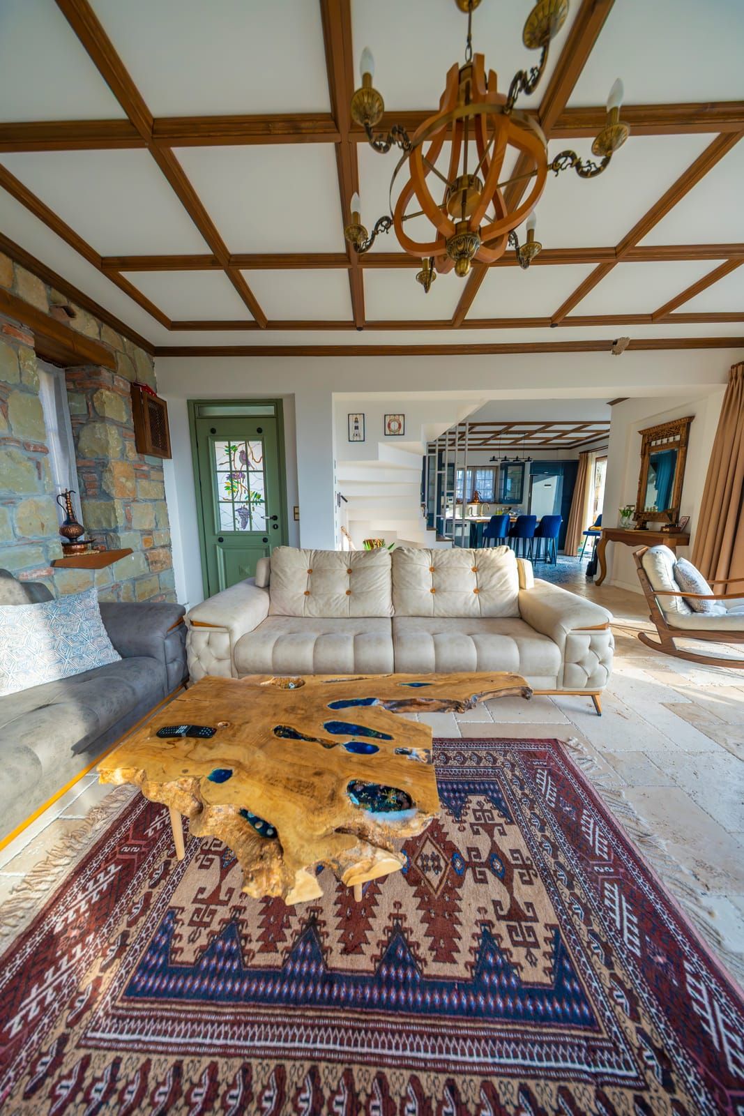 Yüksek ahşap tavanlı salon, kilim ve antika parçalar